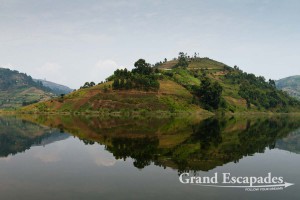 Our boat gracefully plowed the dark waters of Lake Bunyonyi Uganda. Not a ripple disfigured the smooth tarmac - like surface, allowing the carefully terraced green hills to be mirrored in the supposedly 2.000 meter deep lake